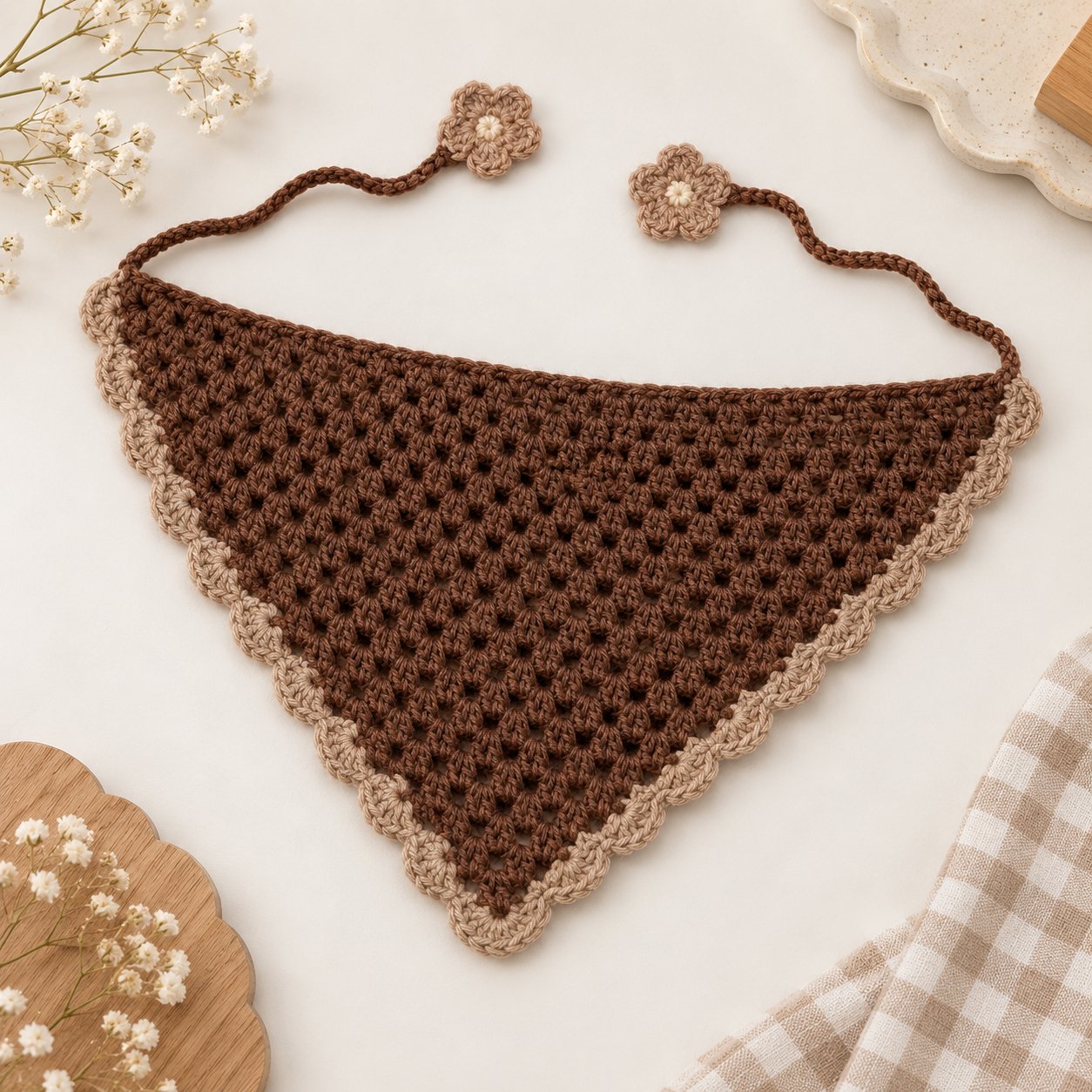 Brown triangular crochet bandana with beige scalloped edging and long tie straps