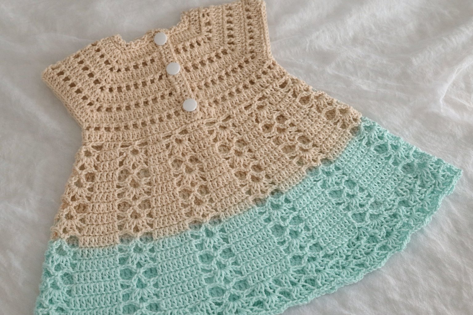 Two-colour crochet baby dress with a raglan yoke and fan shell skirt